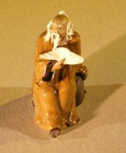 unknown Miniature Figurine: Man Holding a Fan Sitting on a Rock - Brown Color - Fine Detail