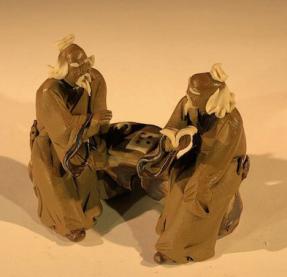 Ceramic Figurine<br>Two Mud Men Sitting On A Bench Reading Books - 2.5