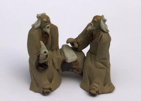 Ceramic Figurine<br>Two Mud Men Sitting On A Bench Holding Pipe<br>2