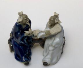 Ceramic Figurine<br>Two Men Sitting On A Bench Holding Fan & Pipe- 2.25