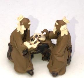 Miniature Ceramic Figurine<br>Two Mud Men Sitting On A Bench Reading Books - 1.5